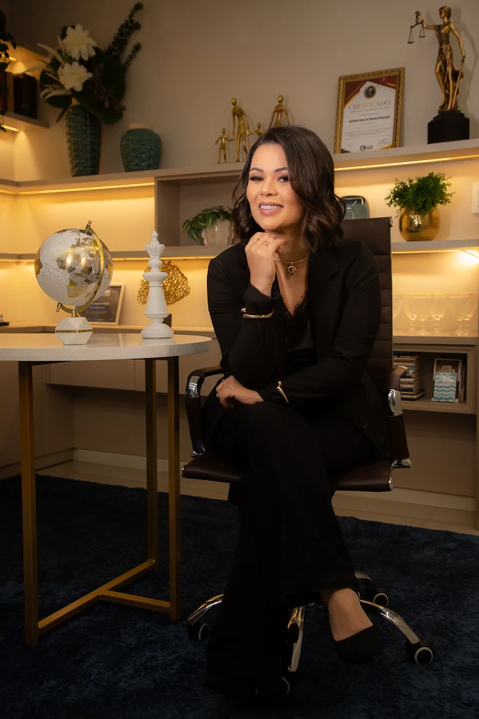 Dra. Jasciane Souza de Moraes sorrindo, sentada em seu escritório